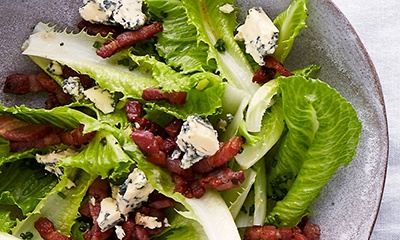 Image of Dolce verde lettuce with hot bacon dressing, chives and crumbled Stilton