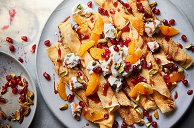 Crepes with labneh, honey and pistachip, with orange segments and pomegranate seeds to garnish