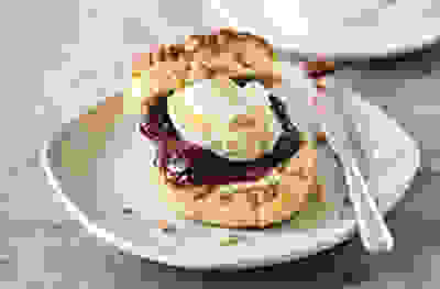 Image of scone covered with jam & cream