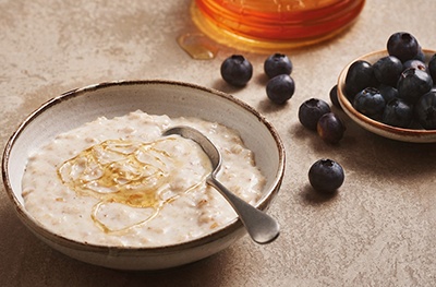 Image of porridge drizzled in honey with a side of berries