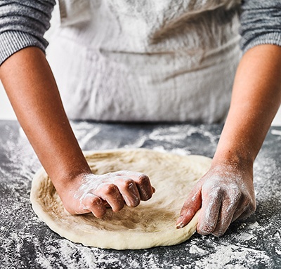 Image of pizza dough shaping to a crust