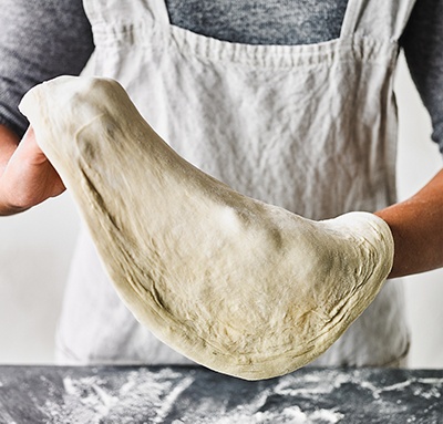 Image of pizza dough being stretched
