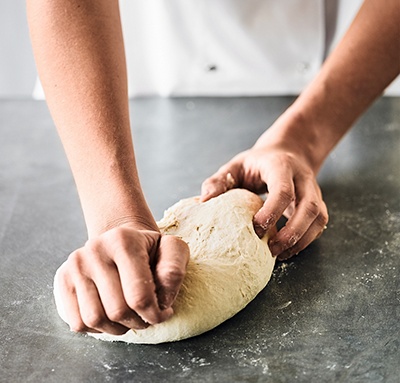 Image of pizza dough being kneaded