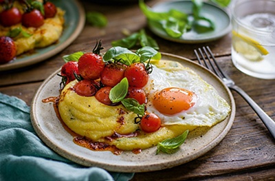 Polenta breakfast bowl with smoky tomatoes & fried eggs
