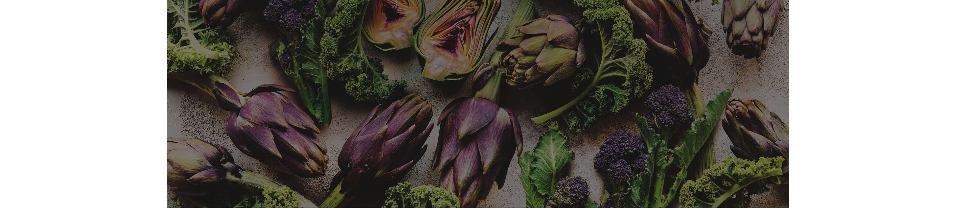 A selection of artichokes, purple sprouting brocolli and kale