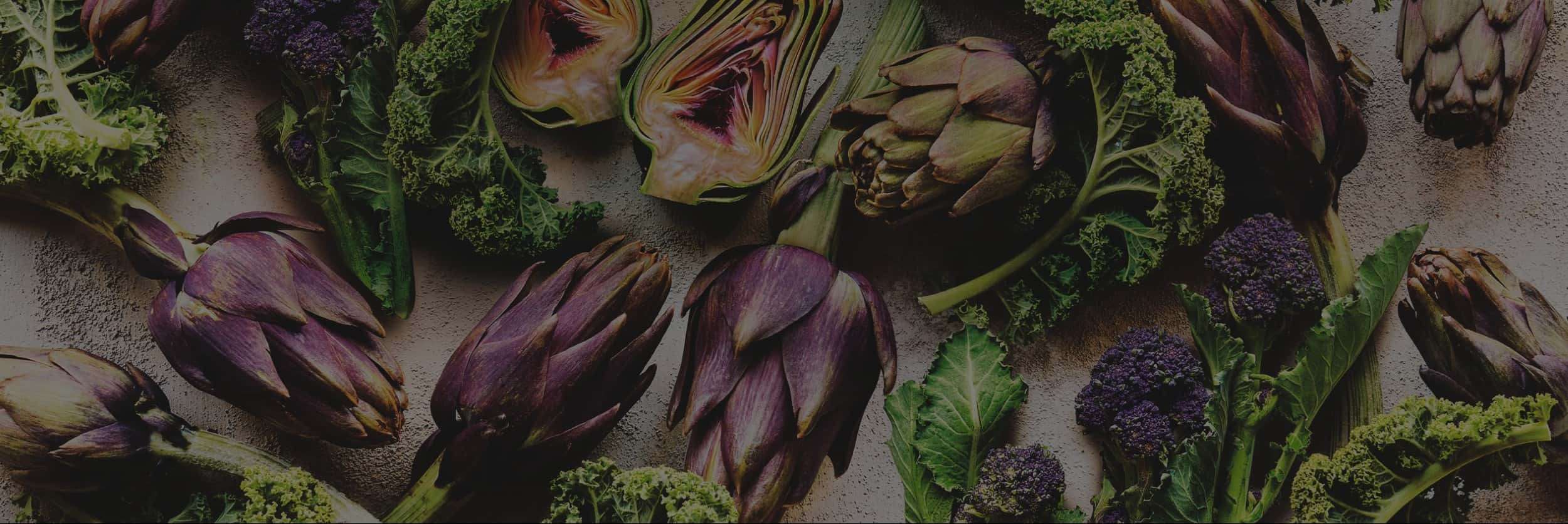 A selection of artichokes, purple sprouting brocolli and kale