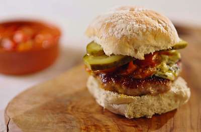 Sausage smash burgers with jammy tomatoes in a burger bun