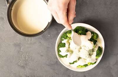 Cheese sauce poured over broccoli