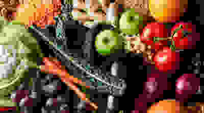 A selection of fresh fruit and vegetables, including apples, tomatoes, carrots and grapes